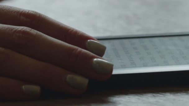 Libro electrónico sobre la mesa con una mano de mujer de cerca — Vídeos de Stock