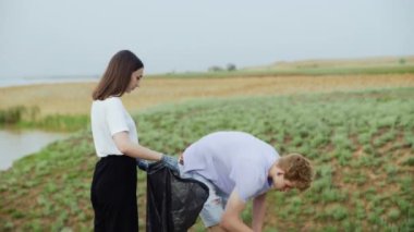 Plajda plastik temizleme ekibi çalışması. Gönüllüler çöp torbasında çöp topluyor. Plastik kirliliği ve çevresel sorun kavramı. Plastikten doğanın gönüllü temizliği.