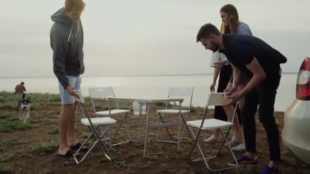 Grupa młodych uśmiechniętych przyjaciół rozmawia na plaży nad morzem — Wideo stockowe