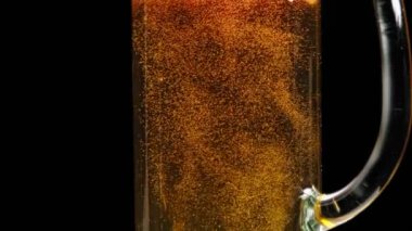 Turuncu sıvıyla dolu bir bardakta kabarcıklar yükseliyor.