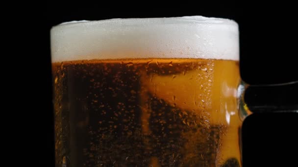 Macro tiro detalhado de bolhas de gás e espuma de cerveja na caneca. Um copo de cerveja artesanal fria e saborosa de perto. As bolhas aumentam rapidamente no líquido de cerveja dourada. Movimento lento. — Vídeo de Stock