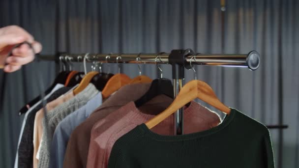 Großaufnahme einer Frau hängt eine Tasche mit Kleidung an einem Kleiderbügel — Stockvideo