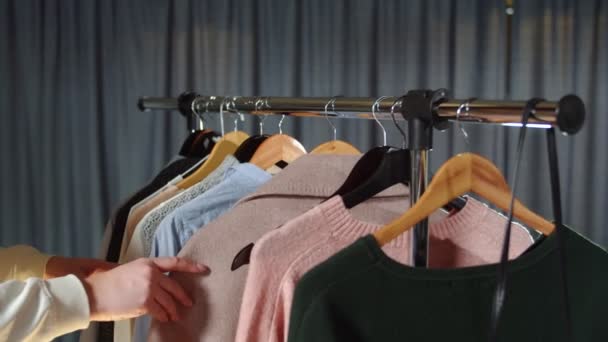 Primer plano de la mujer mira la ropa en la percha — Vídeos de Stock