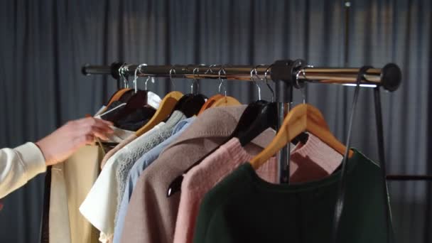 Close up of woman looks at clothes on hanger — Stock Video