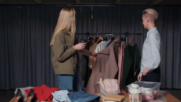 Dos mujeres vendedor y cliente hablan de ropa en la tienda de segunda mano — Vídeos de Stock