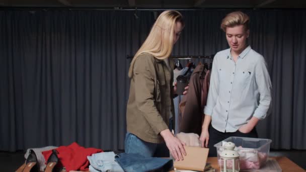 Zwei Verkäuferinnen und eine Kundin sprechen im Second-Hand-Laden über Kleidung — Stockvideo