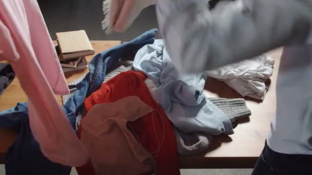 Gros plan sur les femmes Travailleurs de seconde main trier les vêtements sur la table — Video