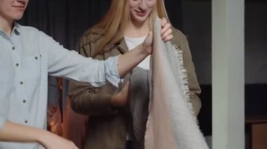 Kadınların etrafını sarın. İkinci el dükkanında çalışanlar masadaki kıyafetleri ayırın.