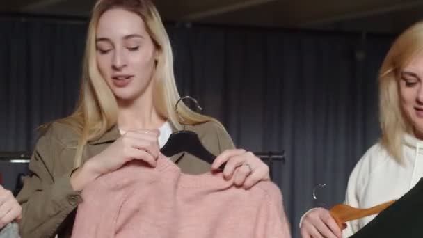 Pozbywanie się kobiet Pracownicy sklepów używanych sortują ubrania na stole — Wideo stockowe