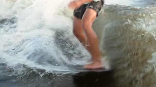 Un surfista saltando sobre un wakeboard. Un experimentado wakeboarder rocía agua en la cámara. — Vídeos de Stock