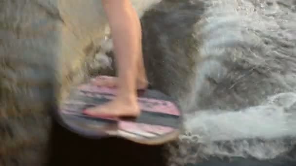 Een surfer springt op een wakeboard. Een ervaren wakeboarder spuit waterdruppels in de camera. — Stockvideo