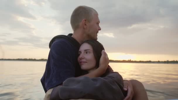 Chlap a holka mazlit roztomilý při západu slunce sedí na lodi — Stock video