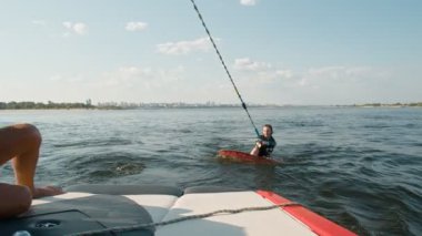 Kız sörfçü, wakeboard kullanıyor. Deneyimli bir wakeboardcu bir kıza yardım eder.