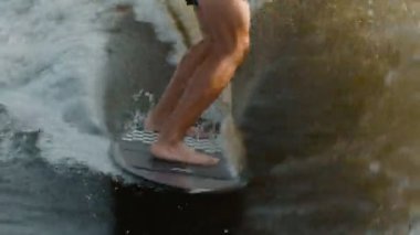 Wakeboard 'a atlayan bir sörfçü. Deneyimli bir wakeboardcu kameraya su püskürtür..