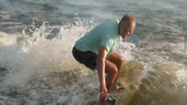 Сёрфер прыгает на вейкборде. Опытный постоялец брызгает водой в камеру.. — стоковое видео
