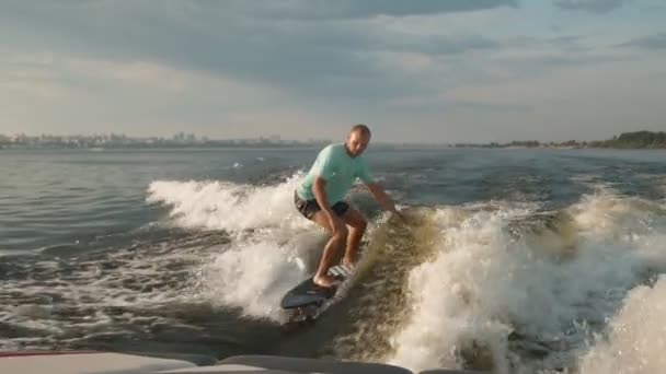 Surfař skákající na wakeboardu. Zkušený wakeboarder rozstřikuje do kamery kapky vody. — Stock video