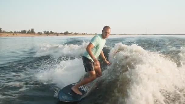 Un surfeur sautant sur un wakeboard. Un wakeboarder expérimenté pulvérise de l'eau dans la caméra. — Video