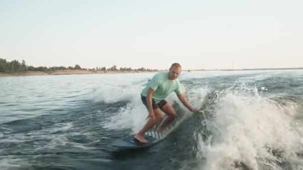 Un surfeur sautant sur un wakeboard. Un wakeboarder expérimenté pulvérise de l'eau dans la caméra. — Video