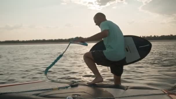 Muž na motorovém člunu s wakeboardem — Stock video