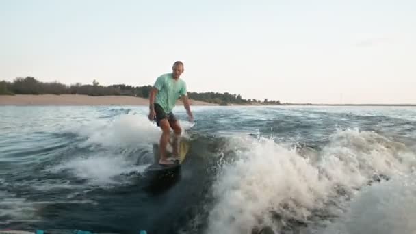 Un surfeur sautant sur un wakeboard. Un wakeboarder expérimenté pulvérise de l'eau dans la caméra. — Video