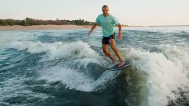 Un surfeur sautant sur un wakeboard. Un wakeboarder expérimenté pulvérise de l'eau dans la caméra. — Video