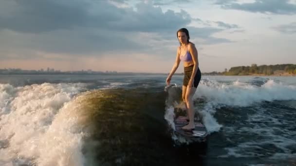 Surfařka skákající na wakeboardu. Zkušený wakeboardista cáká vodu kapky do kamery. — Stock video