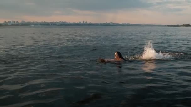 Eine Frau schwimmt auf einem Wakeboard und lächelt — Stockvideo