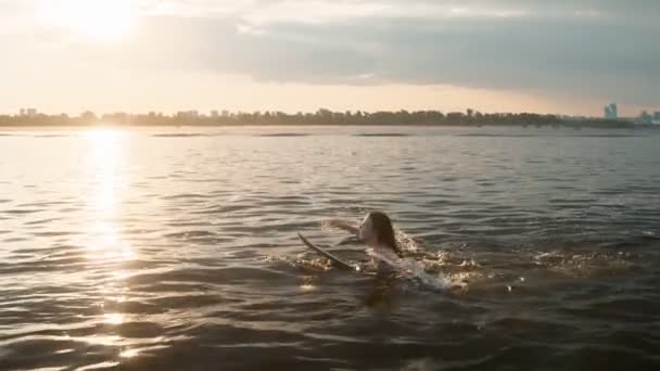 Una mujer nada en un wakeboard y sonríe — Vídeo de stock