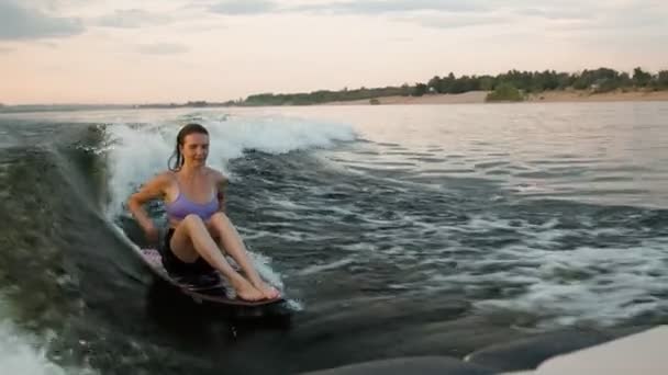 Une surfeuse sautant sur un wakeboard. Un wakeboarder expérimenté éclabousse des gouttes d'eau dans la caméra. — Video