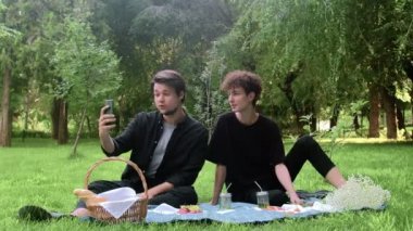 İki adam yazın doğada telefonla video bağlantısıyla iletişim kuruyor.