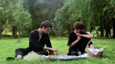 Yazın doğada satranç oynayan iki genç adam.