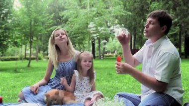 Yazın ailesiyle birlikte sabun köpüklerine izin veren bir adam.