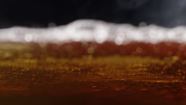 Makroaufnahme feiner Blasen, die in einem Glas mit orangefarbener Flüssigkeit aufsteigen — Stockvideo