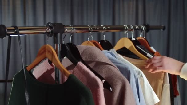 Close up of woman looks at clothes on hanger — Stock Video