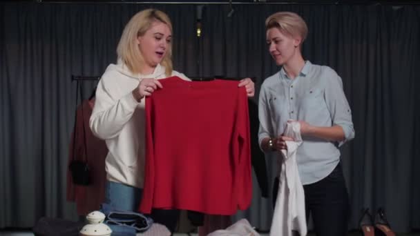 Jonge vrouwen Tweedehands winkelpersoneel sorteren kleding op tafel — Stockvideo