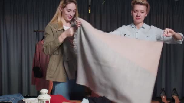 Jeunes femmes Travailleurs d'occasion trier les vêtements sur la table — Video