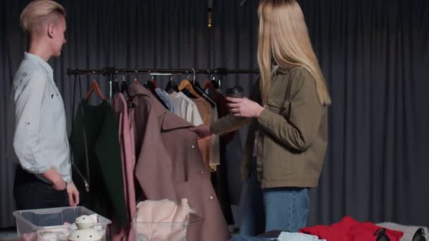 Två kvinnor säljare och kund talar om kläder i second hand shop — Stockvideo
