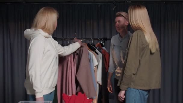 Jeune femme essaie un manteau rose dans la boutique de vêtements d'occasion — Video