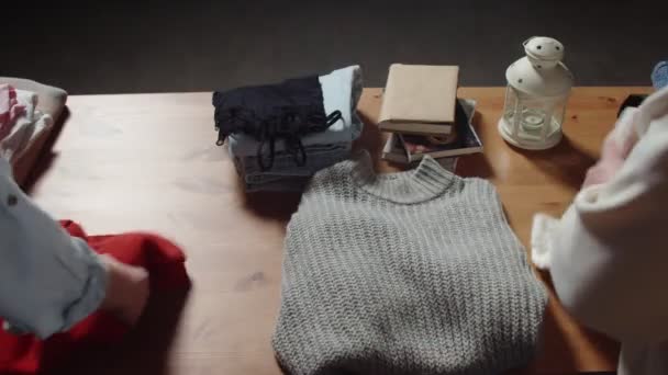 Mujer irreconocible se prueba un suéter gris en la tienda de ropa de segunda mano — Vídeos de Stock