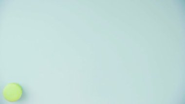 Pastel mavi arka planda çok renkli Fransız makarnalı kurabiyelerin üst görüntüsü. Bir kadın eli kurabiye serer.