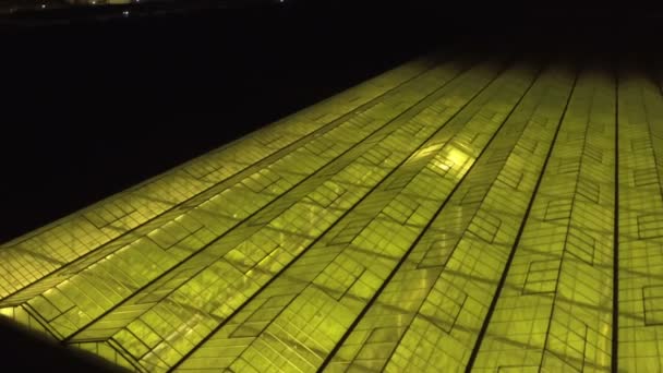 Fondo geométrico verde abstracto. Invernaderos iluminados por la noche. Infraestructura agrícola en techos de vidrio. — Vídeos de Stock