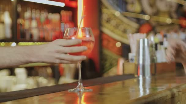 La main des barmans met un cocktail sur la table du bar pour une fille, gros plan — Video