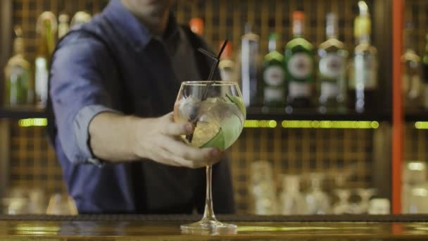 Le barman a apporté un verre, un cocktail alcoolisé, et l'a mis sur le comptoir. Gros plan — Video