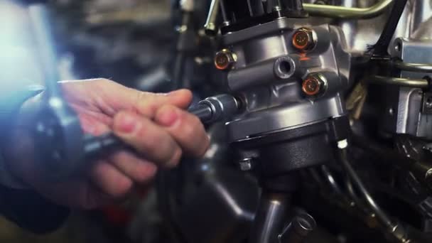 Um mecânico de automóveis trabalha em um motor de carro na garagem mecânica. Serviços de reparação. Close-up — Vídeo de Stock