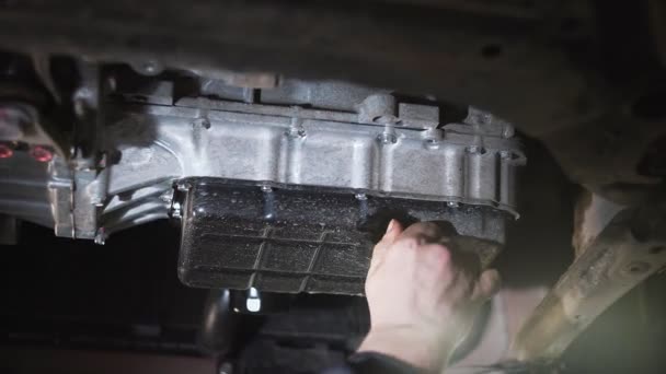 Автомеханік замінює масло в двигуні автомобіля . — стокове відео