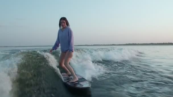 Surfařka skákající na wakeboardu. Zkušený wakeboardista cáká vodu kapky do kamery. — Stock video