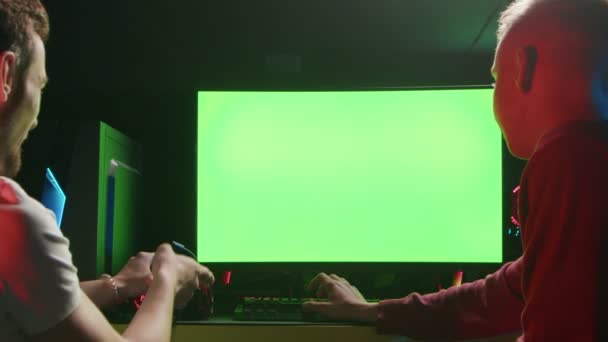 Dua orang sedang duduk di depan komputer dan melihat layar hijau — Stok Video