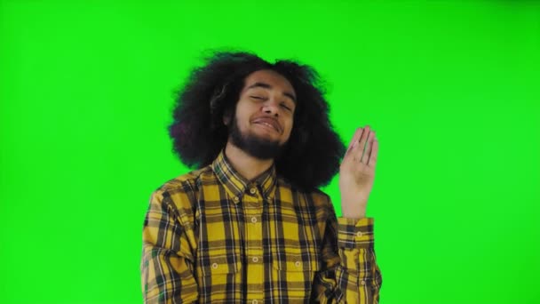Bla, bla, bla. Een verveelde Afro-Amerikaan, gebaar met een blah-blah gebaar, moe van gesprekken en oninteressante informatie, poseren op een groene achtergrond — Stockvideo