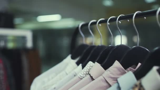 Sklep odzieżowy z ubraniami na wieszakach.Close-up — Wideo stockowe