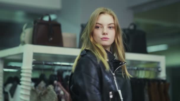 可愛い女の子が衣料品店で服を試着している。ショッピング — ストック動画